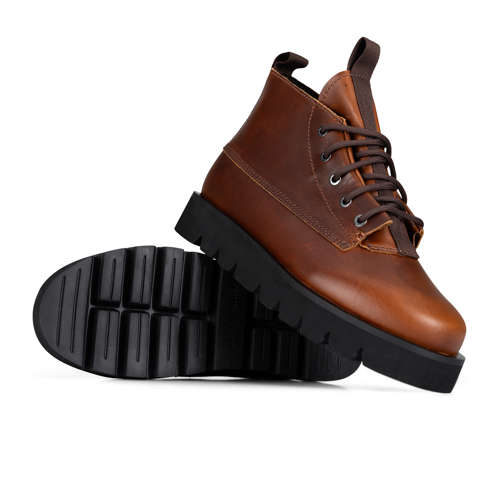 A pair of brown leather lace-up ankle boots with chunky black lug soles, shown on a clean white background with one boot standing upright and the other lying on its side to display the sole.
