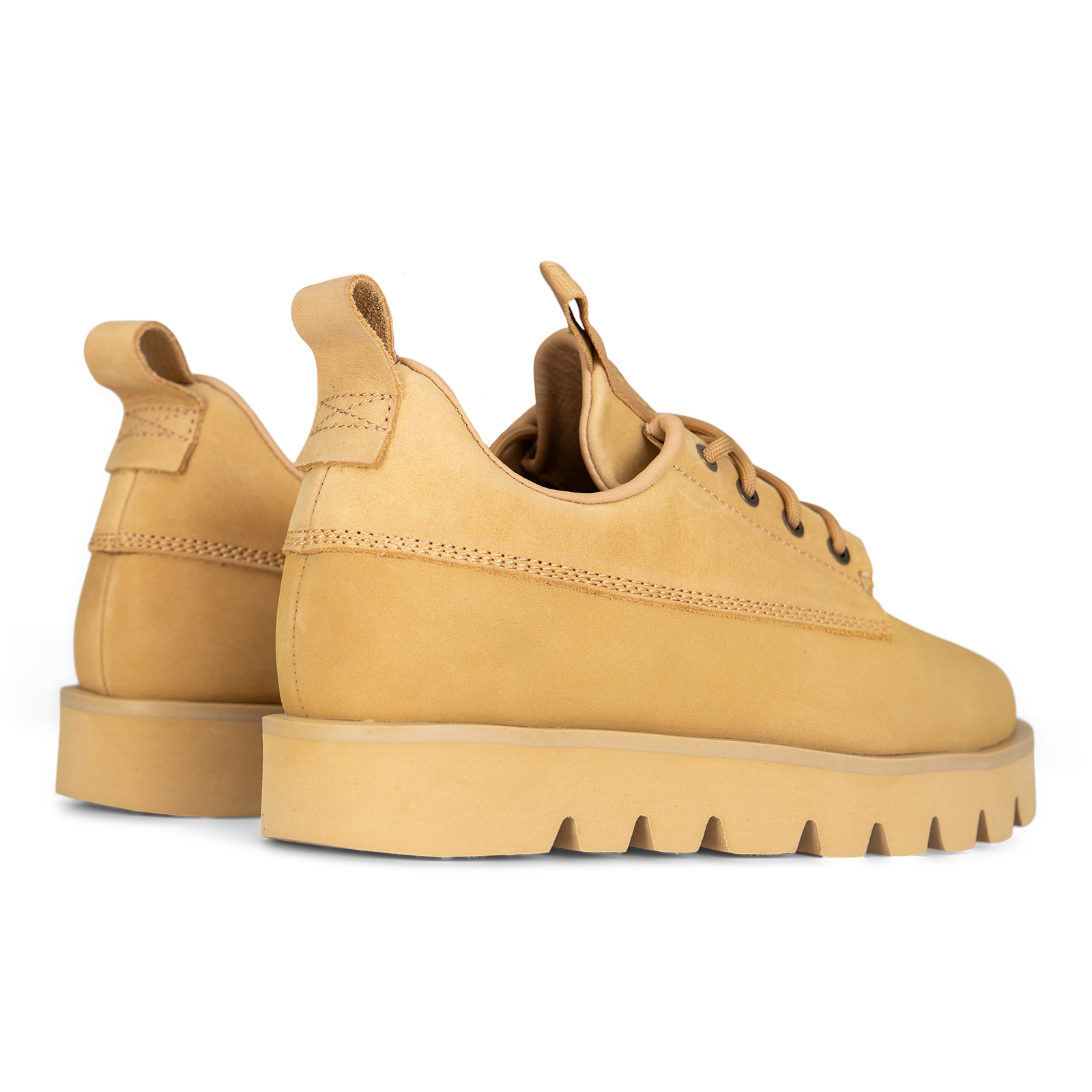 A pair of tan suede lace-up boots with chunky lug soles, shown from a side profile view on a white background.