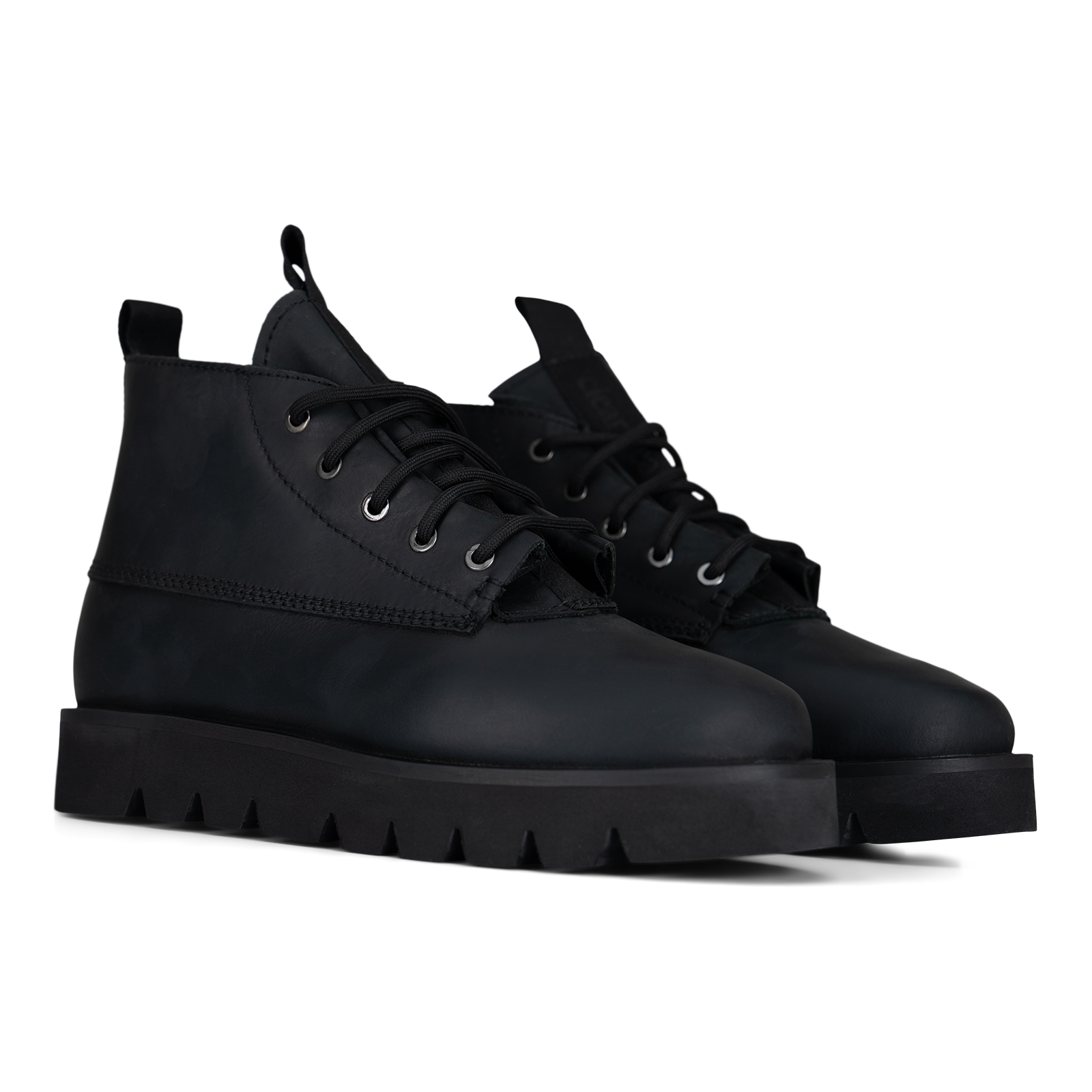 A pair of black leather lace-up ankle boots with chunky lug soles, shown from a three-quarters angle on a white background.