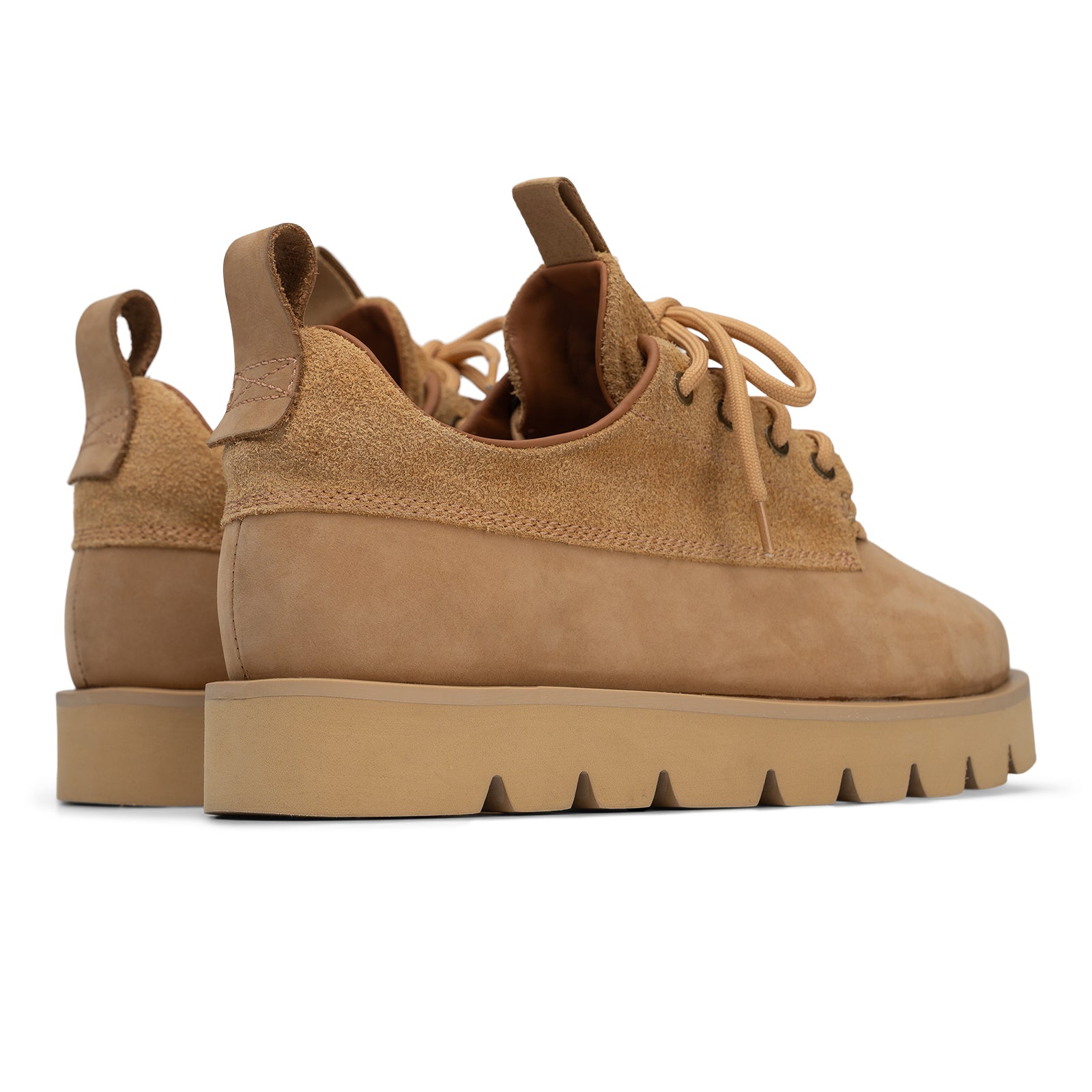 Tan suede shoes with thick sole on a white background