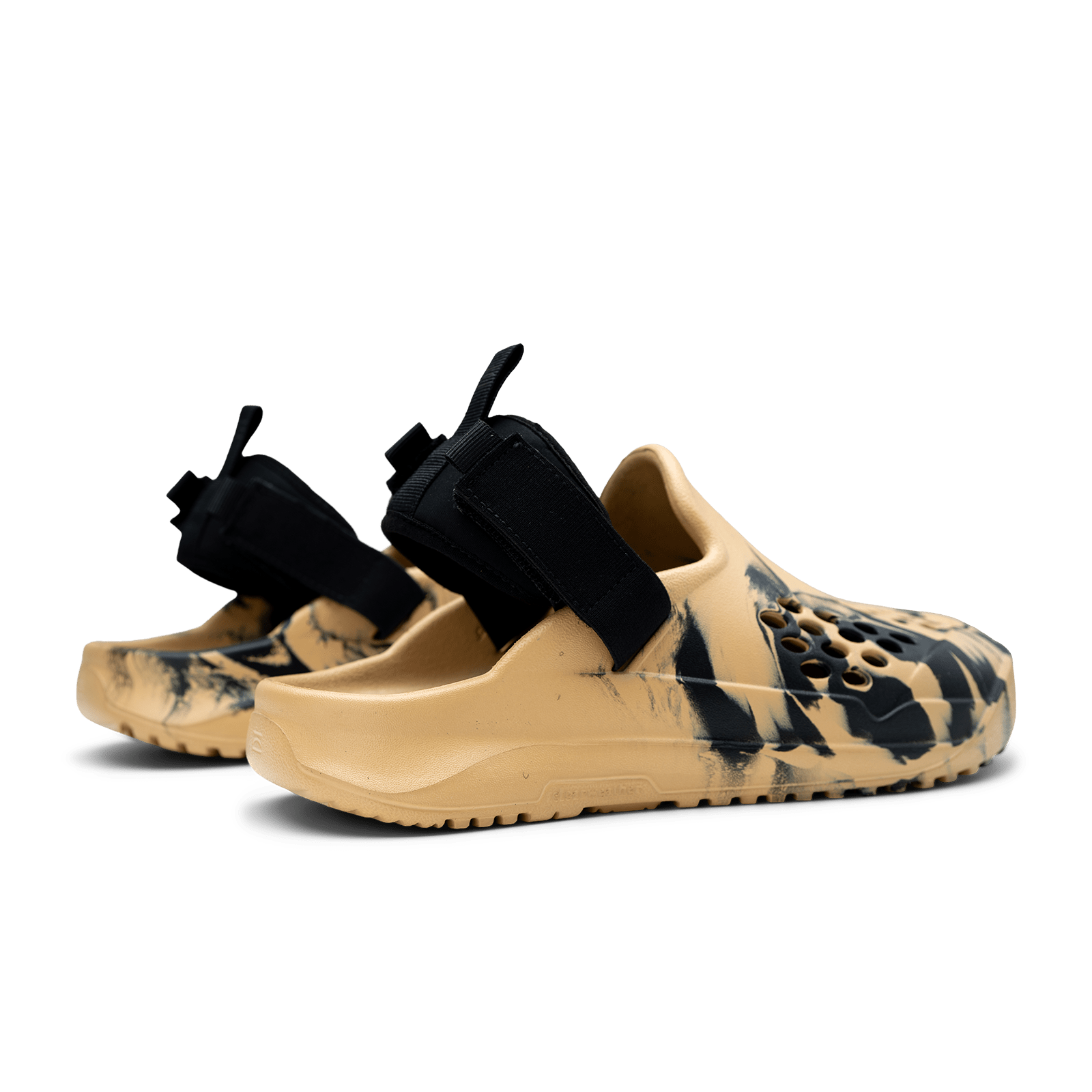 Pair of tan and black shoes with strap details on a white background