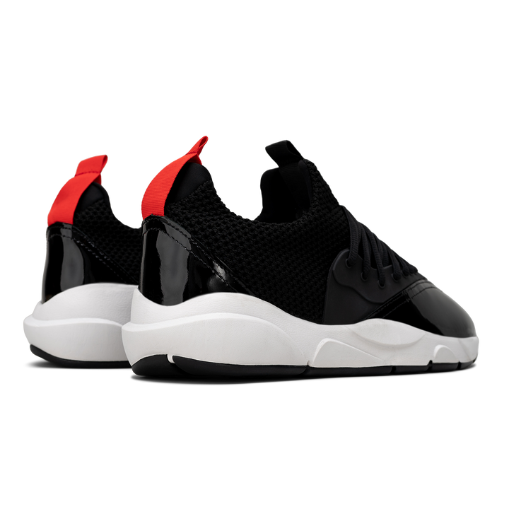 Back 3/4 view, Cloudstryk Advantage is a runner with Black patent leather and suede overlays zoom mesh underlays, red heel pull molded lace holder, white eva midsol and a translucent black rubber outsole.