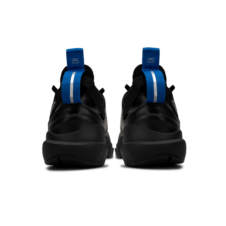 Back view,   Contera Black is a runner with Tumbled Black fullgrain leather overlays Black stretch mesh underlays, Royal Blue heel pull molded lace holder, Black eva midsole and Black rubber outsole.