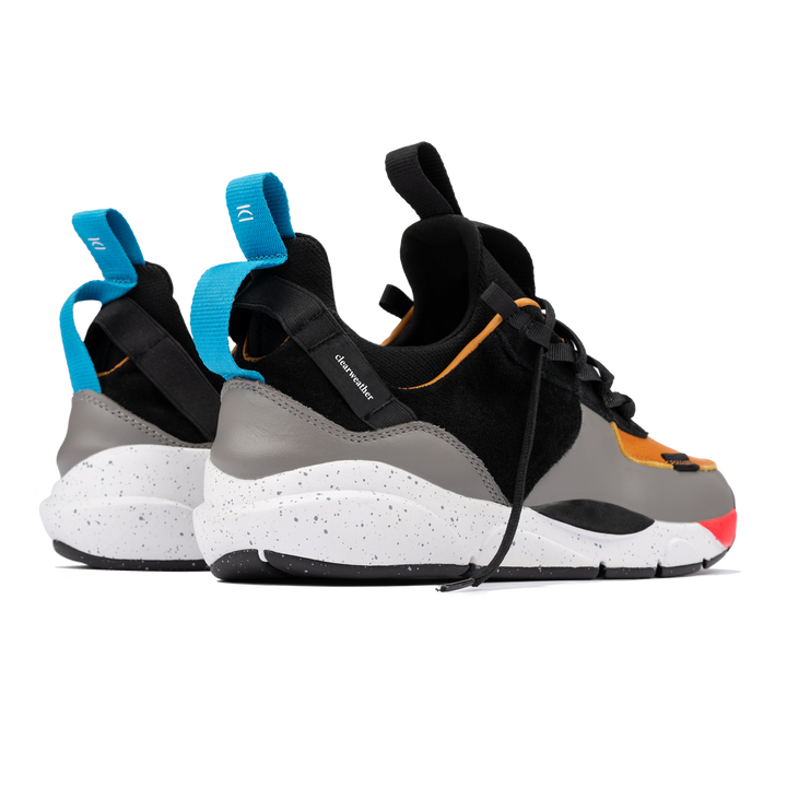Back 3/4 view, The Contera Kalahari is a Runner with grey leather black suede and tabaco orange leather, Blue webbing heel pull, Black webbin tongue pull, Black webbing lace system, painted eva midsole ande black rubber outsole.